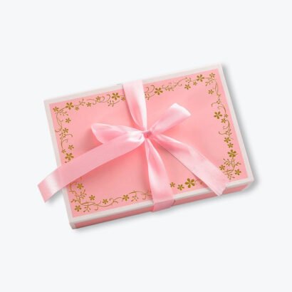 Elegant pink clothing gift box with a decorative gold floral design and a satin ribbon bow, perfect for apparel and gift packaging.