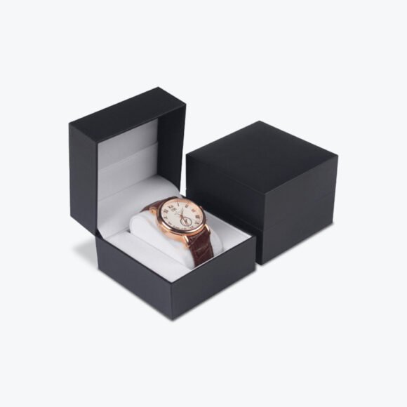 Black luxury watch box with a sleek design, featuring a classic rose gold watch with a leather strap inside.