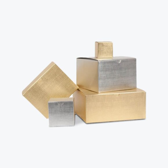 A stack of luxurious gold and silver storage boxes with a metallic finish, perfect for premium apparel and gift packaging.