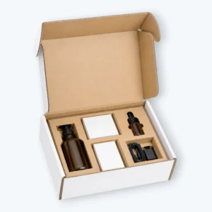 Custom Corrugated Inserts in an open mailer box holding bottles, small boxes, and accessories with fitted compartments